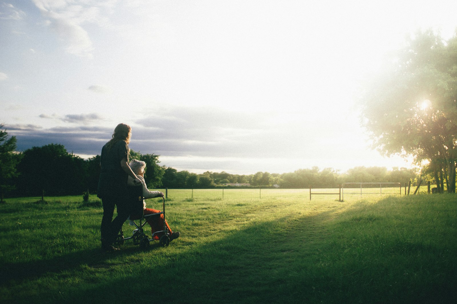 A caregiver assisting a client outdoors, supporting mobility and independence